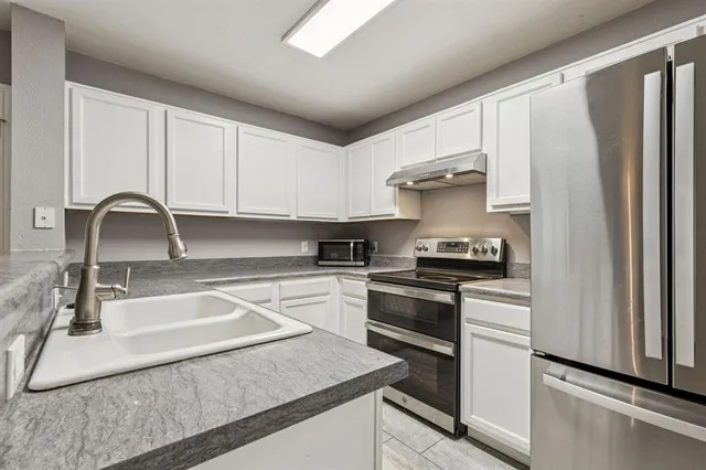 a kitchen with stainless steel appliances granite countertop a sink stove and refrigerator