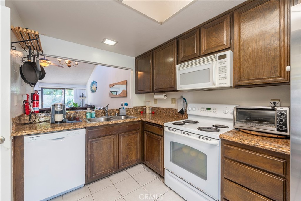 19916 Maritime Lane Huntington Beach, CA 92648 - Photo 11 of 43 a kitchen with stainless steel appliances granite countertop a sink and dishwasher a stove top oven with wooden floor