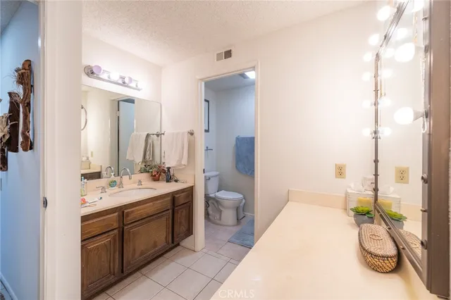a bathroom with a double vanity sink toilet and shower