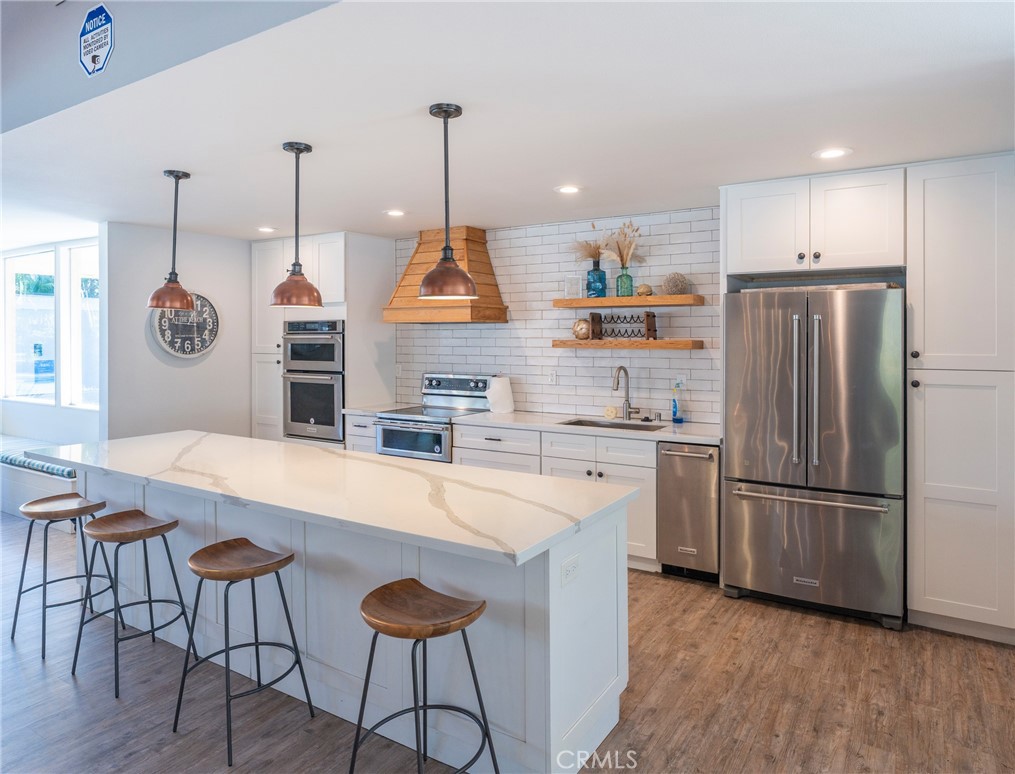 19916 Maritime Lane Huntington Beach, CA 92648 - Photo 34 of 43 a kitchen with stainless steel appliances granite countertop a refrigerator a sink dishwasher a stove and a refrigerator with wooden floor