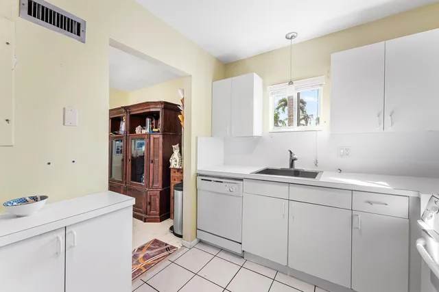 a kitchen with white cabinets sink and appliances