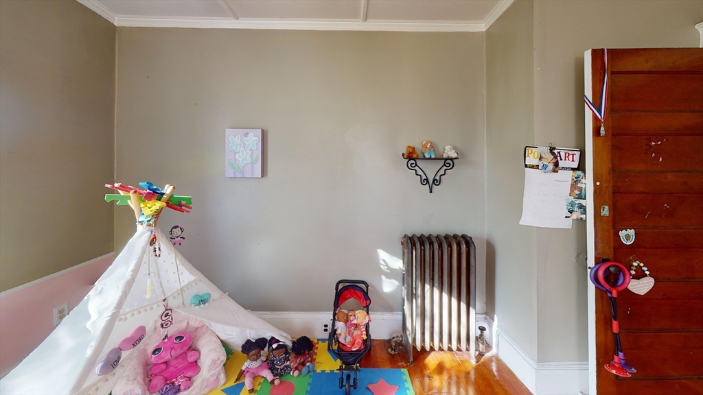 19 Mt Ida Road Boston, MA 02122 - Photo 17 of 36 a bedroom with a bed and a chandelier