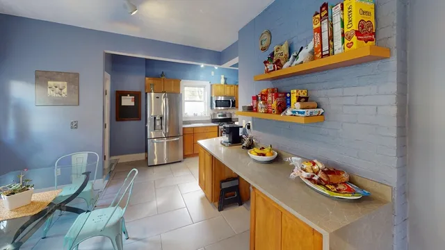 a kitchen with stainless steel appliances a dining table and chairs
