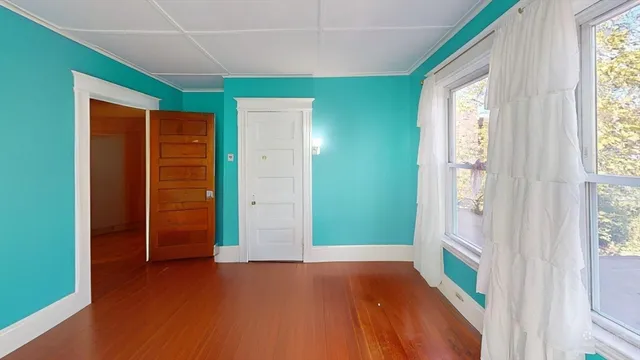 an empty room with closet and windows