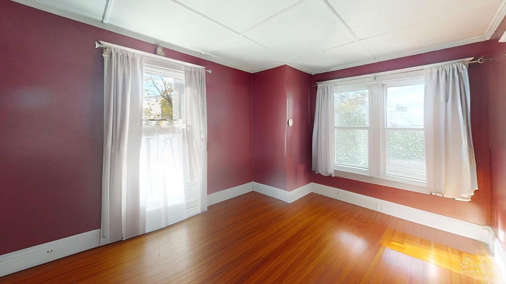 19 Mt Ida Road Boston, MA 02122 - Photo 25 of 36 an empty room with wooden floor and windows