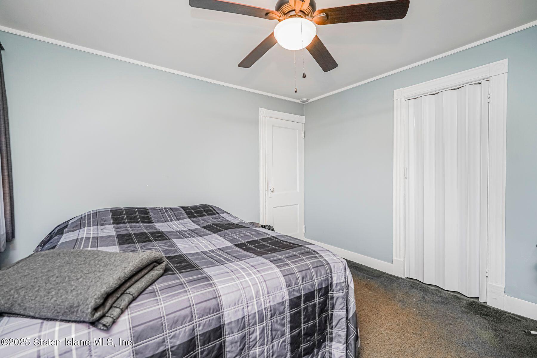 5300 Amboy Road Staten Island, NY 10312 - Photo 16 of 32 a bedroom with a bed and a chandelier