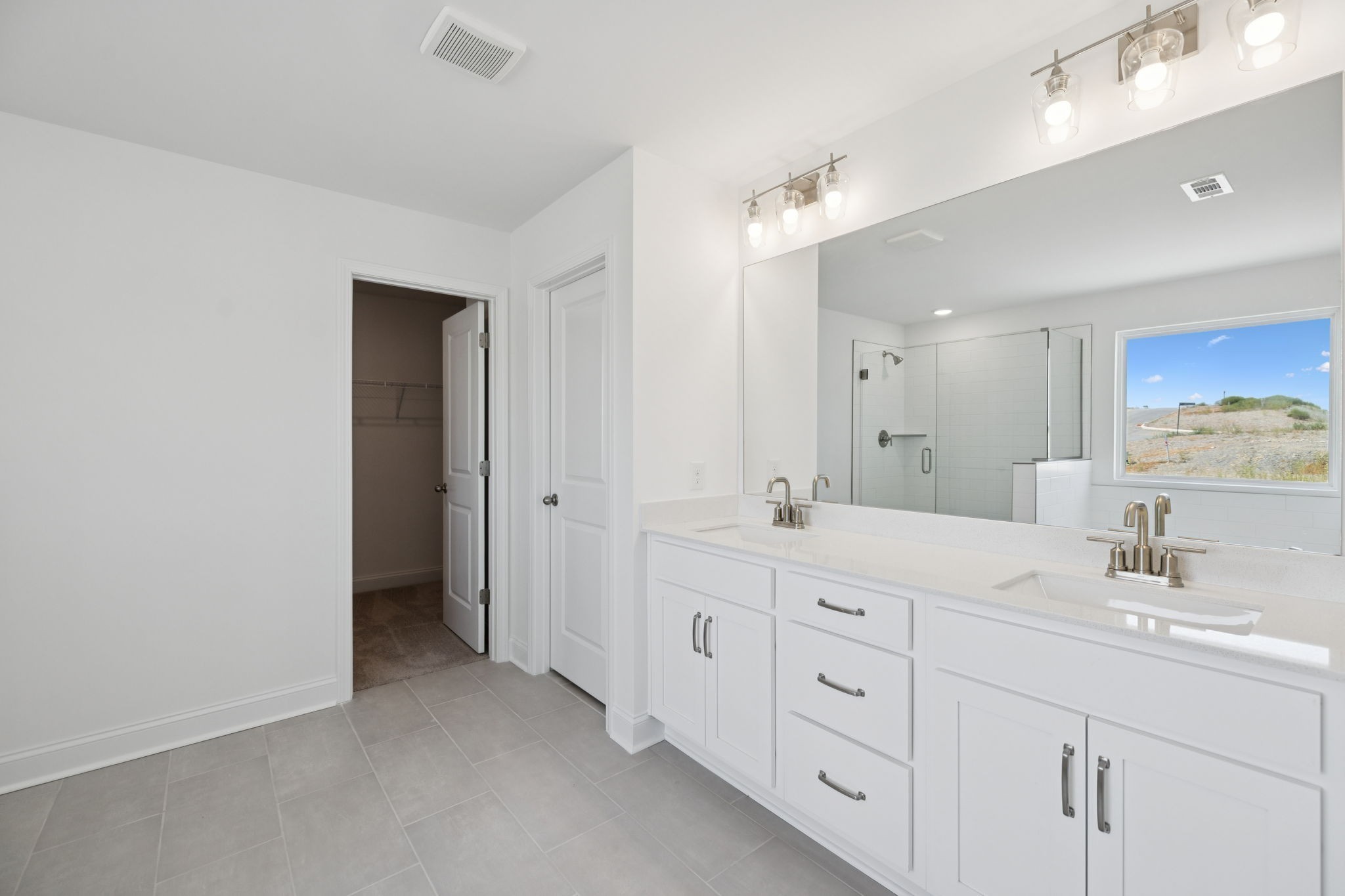 140 Emeline Way Mount Juliet, TN 37122 - Photo 20 of 35 a spacious bathroom with a double vanity sink a large mirror and a shower