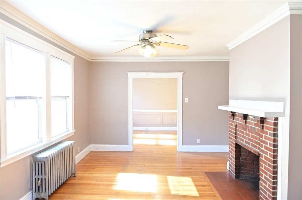 a view of an empty room with a fireplace and a window