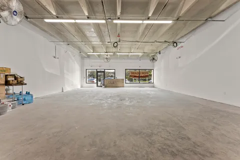 a view of a room with refrigerator a cabinet and a flat screen tv
