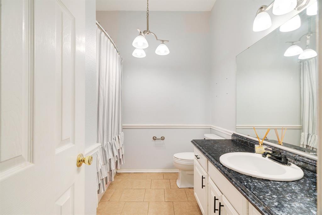 455 Timber Lakes Drive Powderly, TX 75473 - Photo 9 of 18 a bathroom with a sink a toilet and a mirror