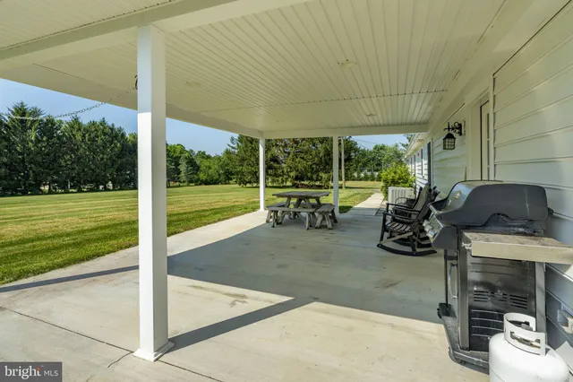 a view of a patio with table and chairs near a garden