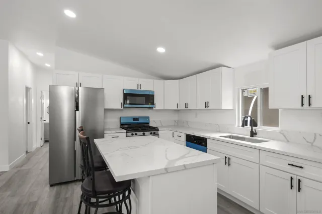 a kitchen with white cabinets and stainless steel appliances