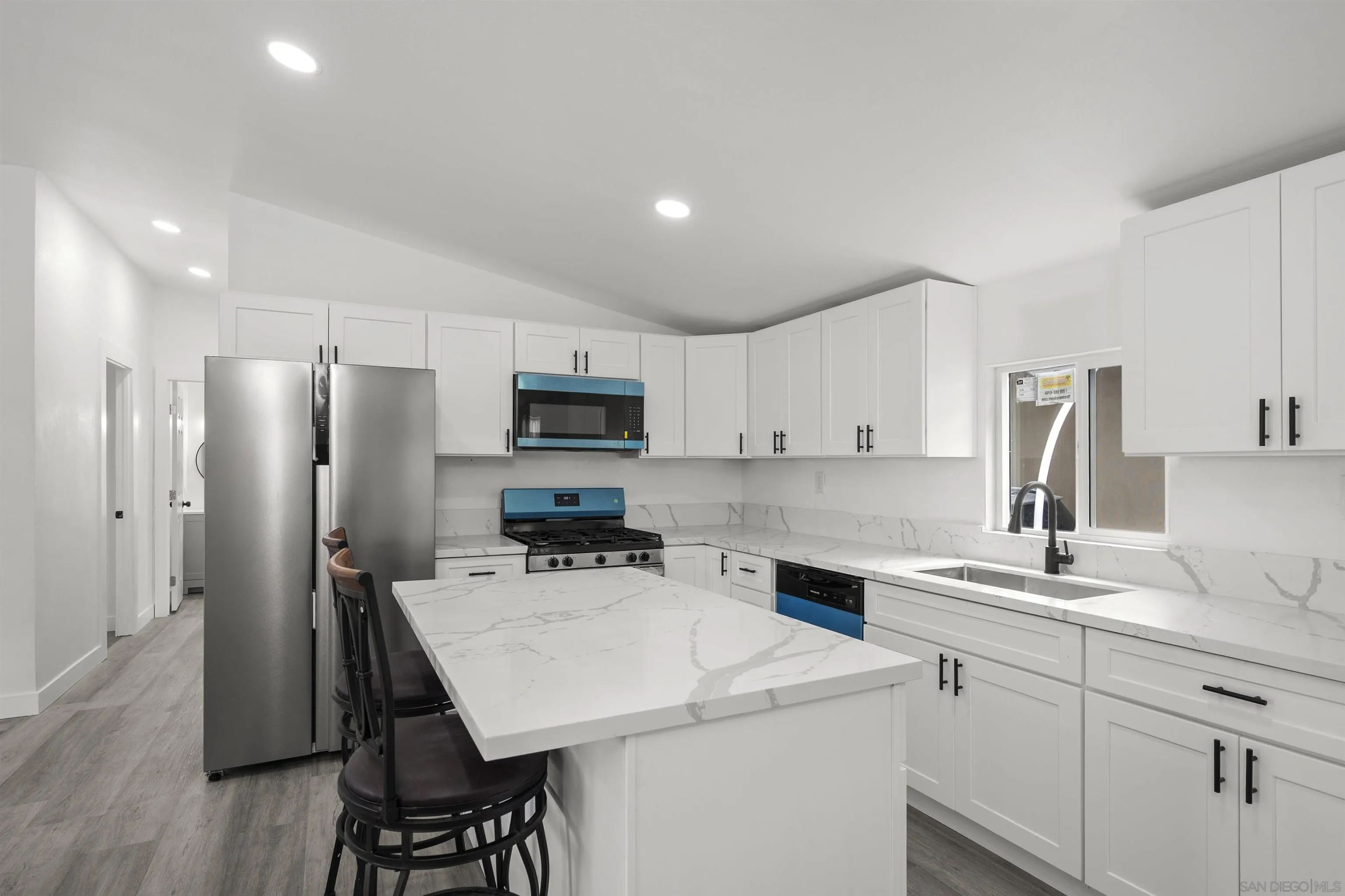 a kitchen with white cabinets and stainless steel appliances