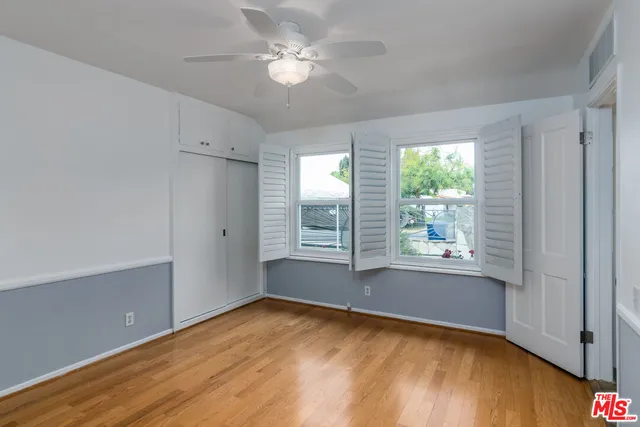 a view of empty room with window and ceiling fan