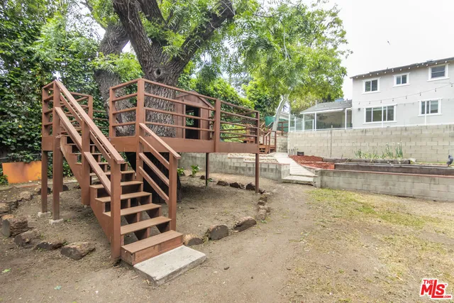 a view of a house with pool and wooden fence