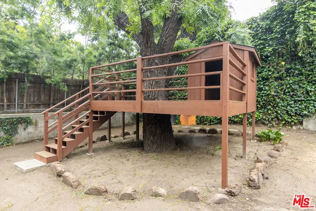 a backyard of a house with outdoor seating and trees