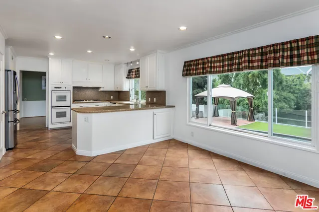 a kitchen with stainless steel appliances a refrigerator and a stove top oven