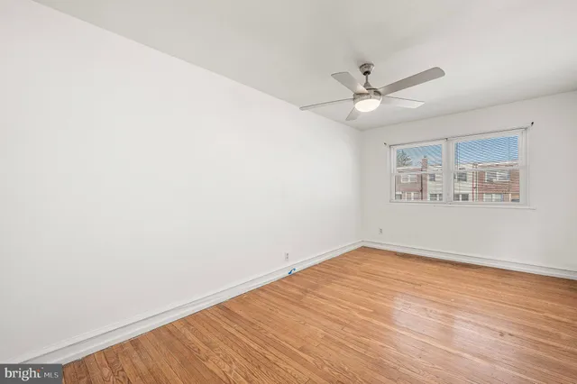 an empty room with a window and ceiling fan
