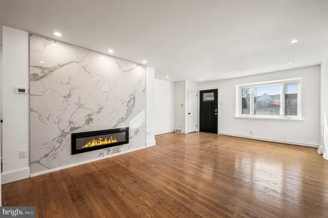 a view of a livingroom with wooden floor and a fireplace