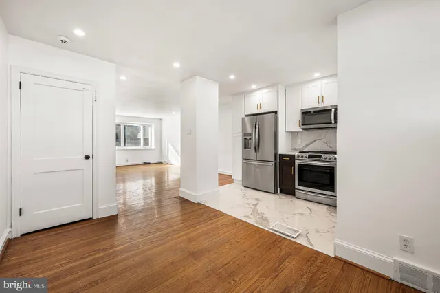 a kitchen with stainless steel appliances a refrigerator and a stove top oven