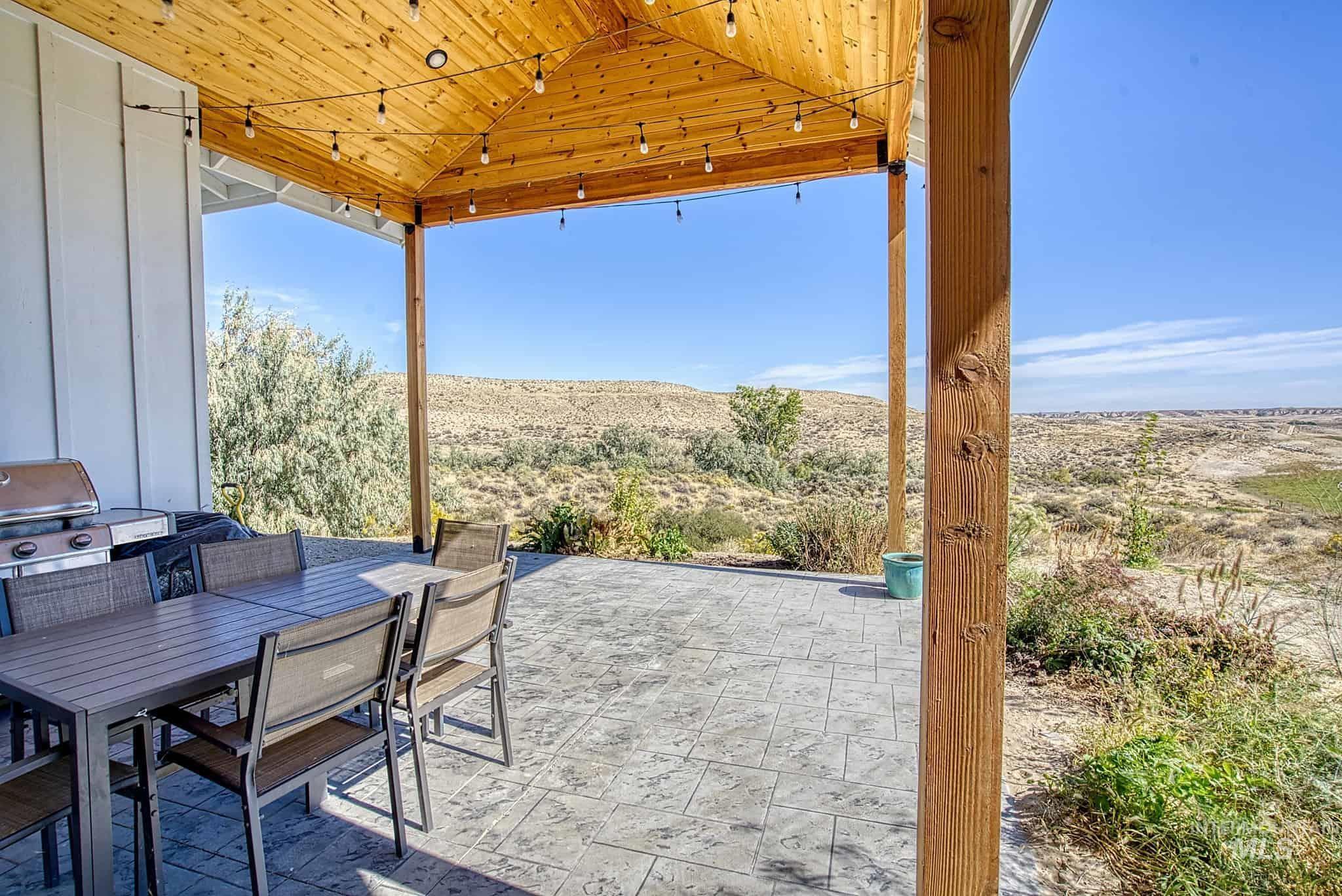 876 Coyote Gulch Road Adrian, OR 97901 - Photo 35 of 50 Expansive outdoor patio with stamped concrete flooring, a natural wood-plank ceiling, and sturdy wood support beams