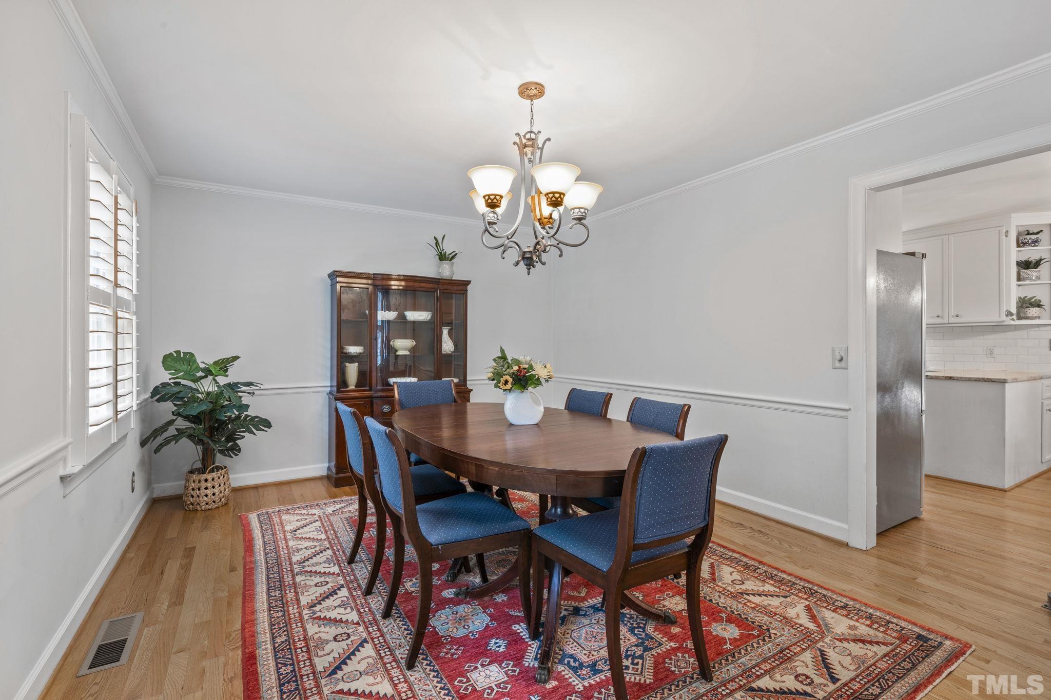 3412 Wembley Court Raleigh, NC 27607 - Photo 20 of 46 a view of a dining room with furniture wooden floor and chandelier