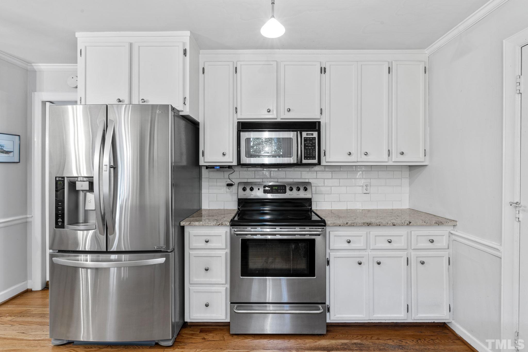 3412 Wembley Court Raleigh, NC 27607 - Photo 10 of 46 a kitchen with cabinets stainless steel appliances and wooden floor