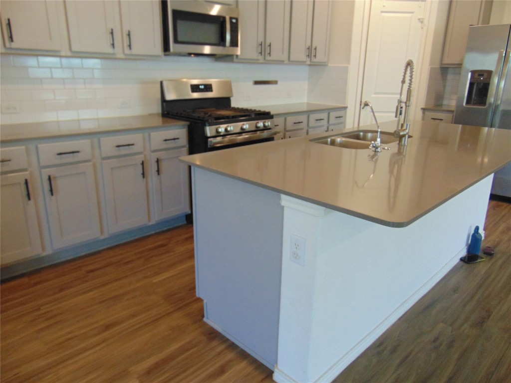 181 Crystal River Road Kyle, TX 78640 - Photo 8 of 12 a kitchen with kitchen island granite countertop a sink a stove and cabinets
