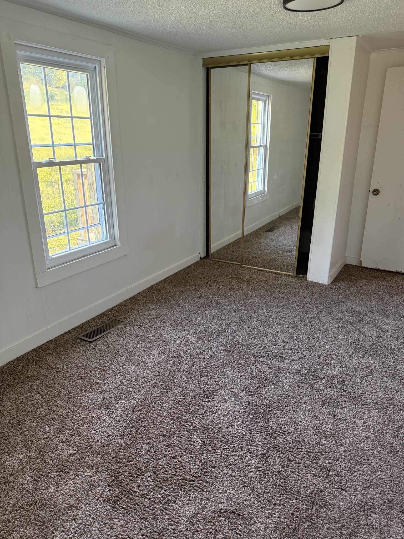 520 Pumpkin Branch Road Dixon Springs, TN 37057 - Photo 23 of 36 an empty room with windows and closet