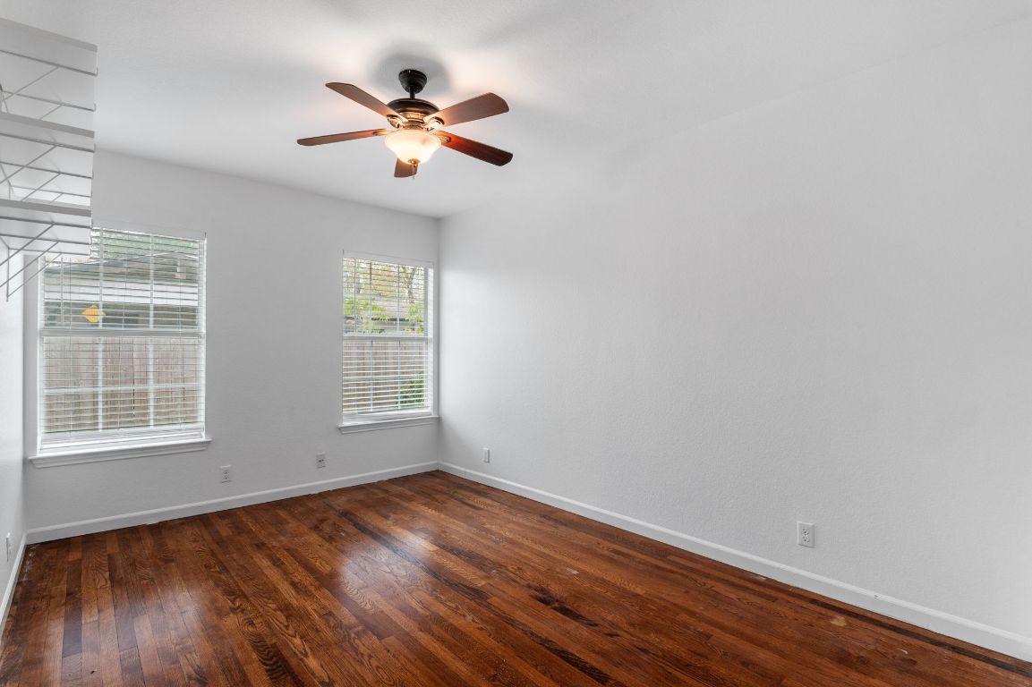 7517 Delafield Lane Austin, TX 78752 - Photo 23 of 39 Unfurnished room with dark wood-type flooring and a ceiling fan