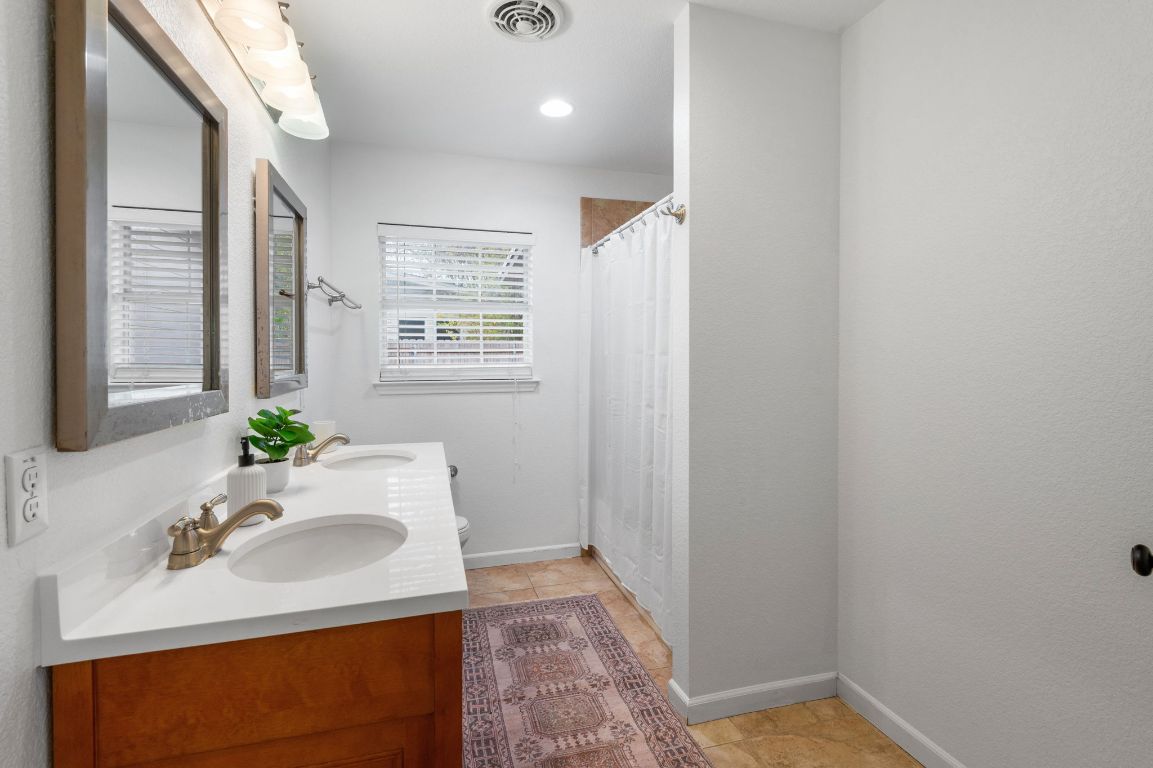 7517 Delafield Lane Austin, TX 78752 - Photo 24 of 39 Full bath featuring a shower with curtain and double vanity