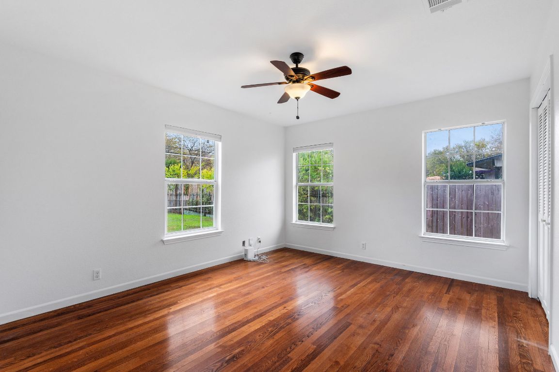 7517 Delafield Lane Austin, TX 78752 - Photo 27 of 39 Empty room featuring dark wood finished floors and a ceiling fan