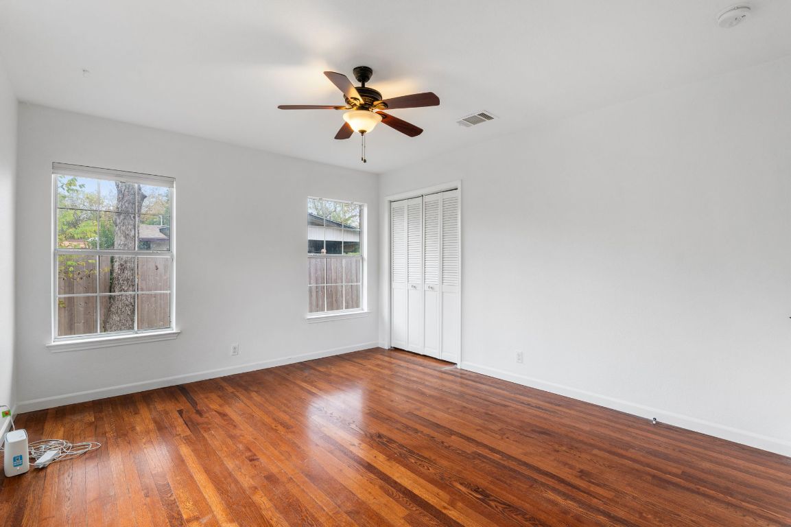 7517 Delafield Lane Austin, TX 78752 - Photo 28 of 39 Unfurnished room featuring dark wood-style flooring and a ceiling fan