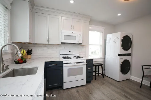 a kitchen with a stove a sink and a microwave with wooden floor