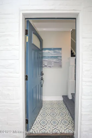 a view of a hallway with wooden floor and a bathroom