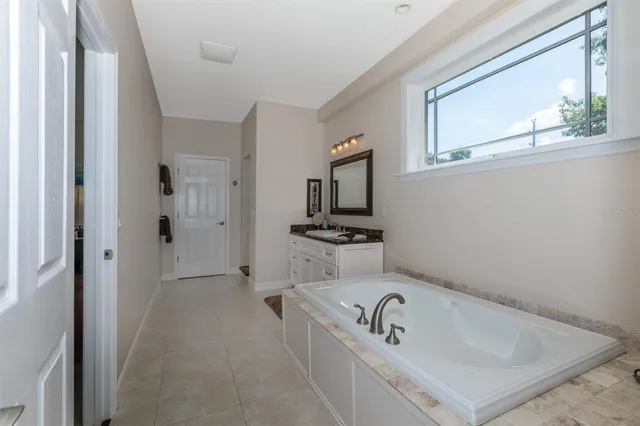 a bathroom with a bathtub a sink and a window