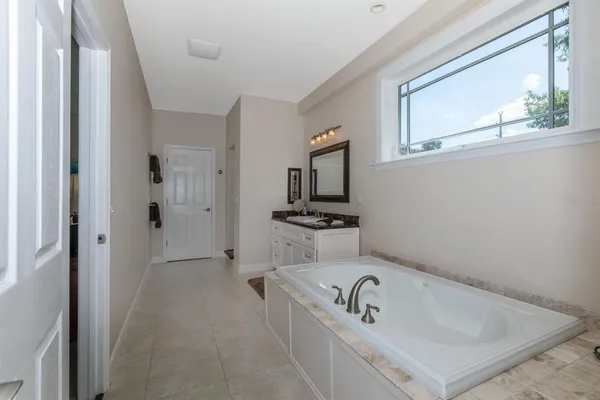 a bathroom with a bathtub a sink and a window