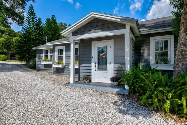 a front view of a house with a yard and trees