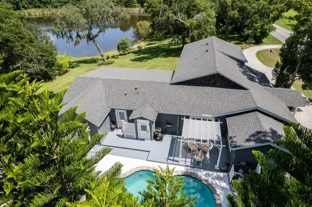 an aerial view of a house with a yard and lake view
