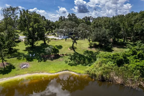 an aerial view of a house with a garden and lake view
