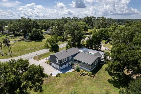 an aerial view of a house with a yard basket ball court and outdoor seating