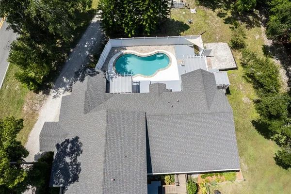 an aerial view of a house with swimming pool and patio