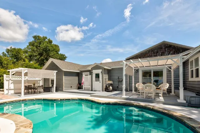 a view of a house with swimming pool and porch with furniture
