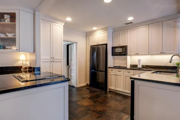 a kitchen with stainless steel appliances granite countertop a refrigerator a stove a sink and a microwave