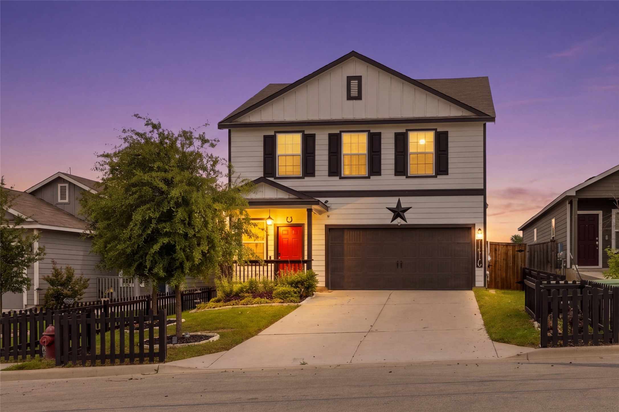 Two-story residential exterior featuring light-colored siding with dark trim accents