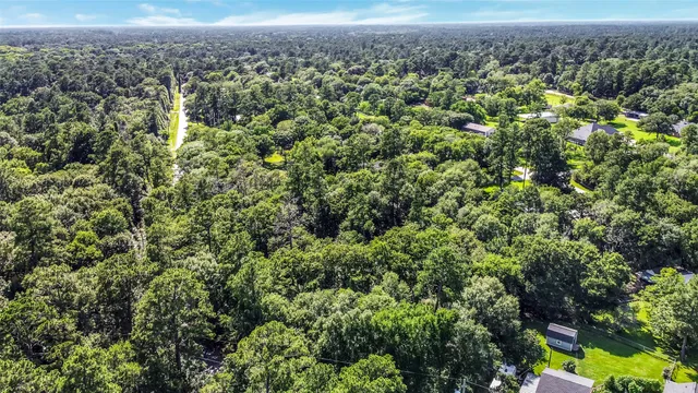 an aerial view of a houses with a yard and mountain view in back
