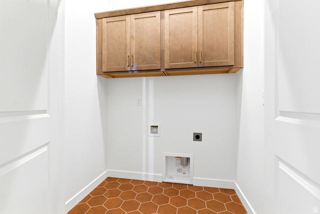 7243 West Terraine Road West Jordan, UT 84081 - Photo 17 of 31 Dedicated utility space featuring hexagonal terracotta-hued tile flooring, light wood cabinetry with gold-toned hardware, and a neutral color palette