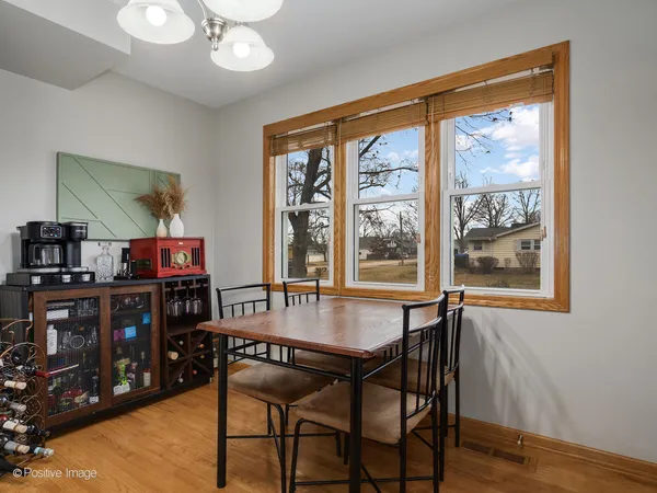 a dining room with wooden floor and large window