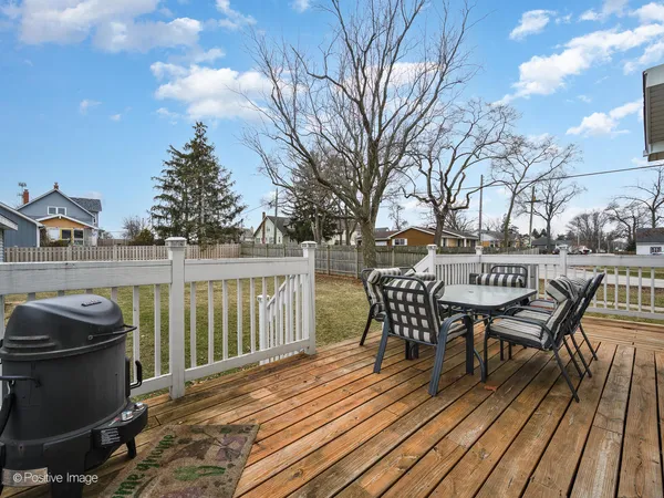 a view of a roof deck with table and chairs and wooden floor