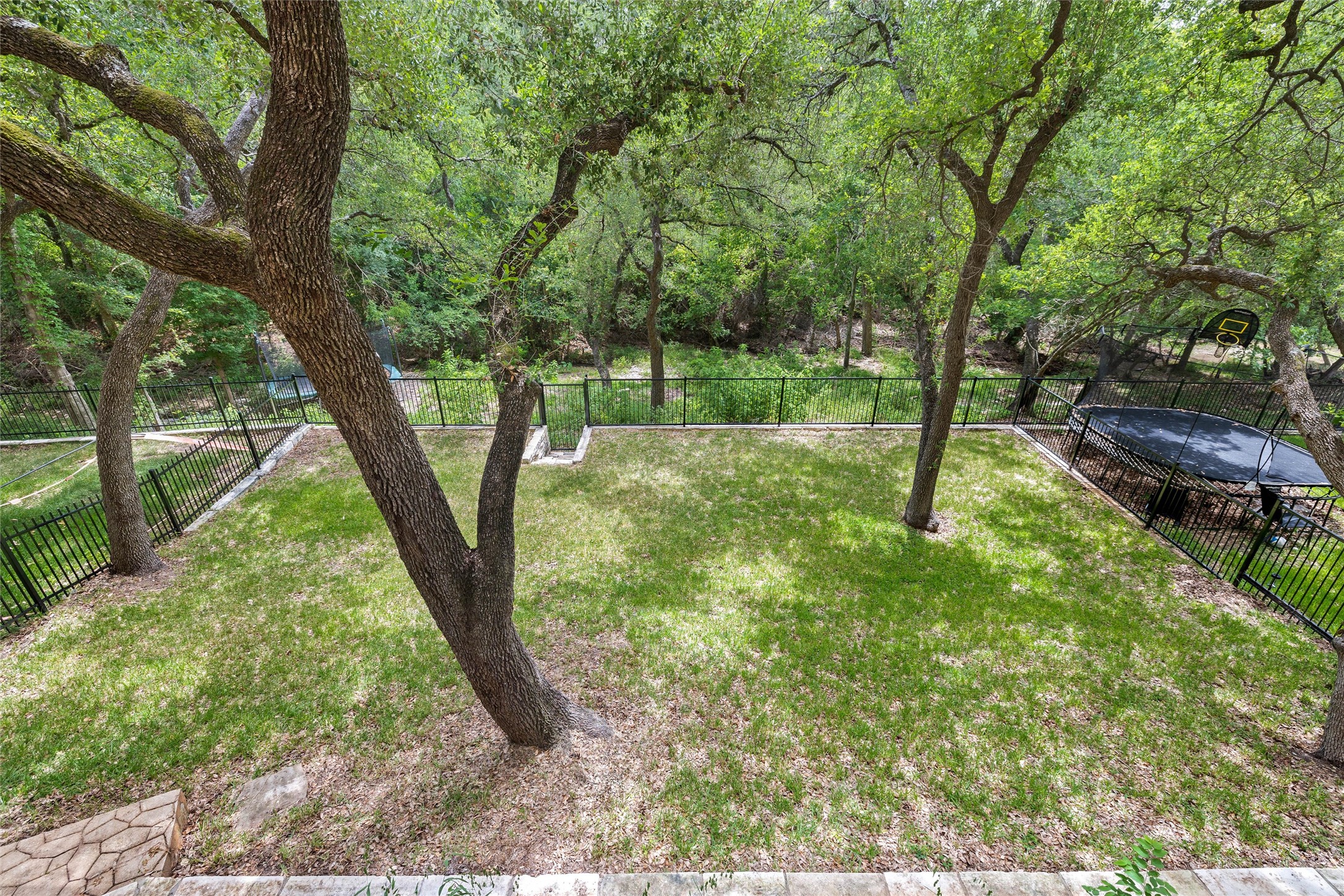 8540 Adirondack Trail, Unit 21 Austin, TX 78759 - Photo 34 of 40 a backyard of a house with lots of plants and large tree